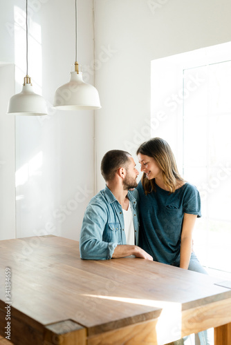 Affectionate couple in love relaxing at home and sitting at table