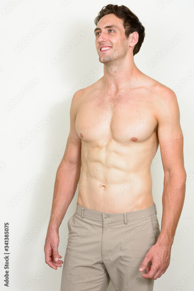 Fototapeta premium Portrait of happy young handsome muscular man thinking shirtless