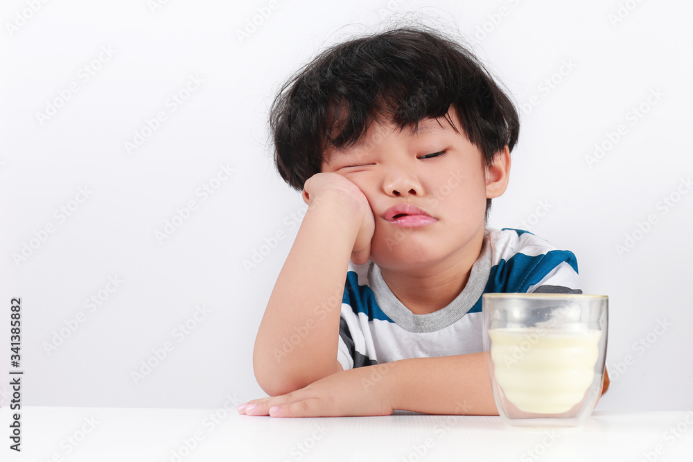 Sad little Asian boy refuses to drink milk Sad little Asian boy refuses to drink milk