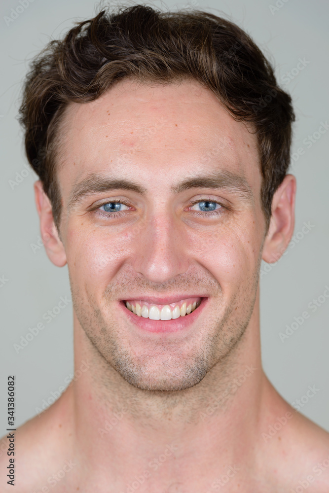 Obraz premium Face of happy young handsome shirtless man smiling