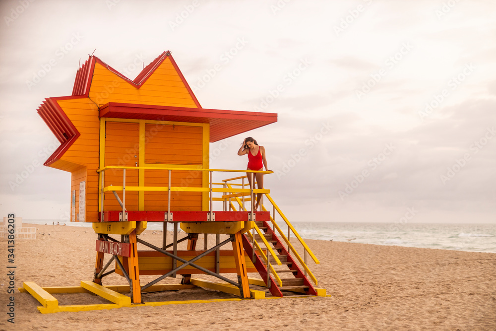 Woman in red swimsuit on lifeguard hut on Miami Beach, Miami, Florida, USA Woman in red swimsuit on lifeguard hut on Miami Beach, Miami, Florida, USA