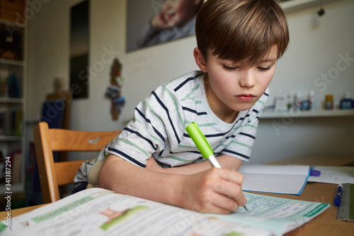 Portrait of boy doing homework photo