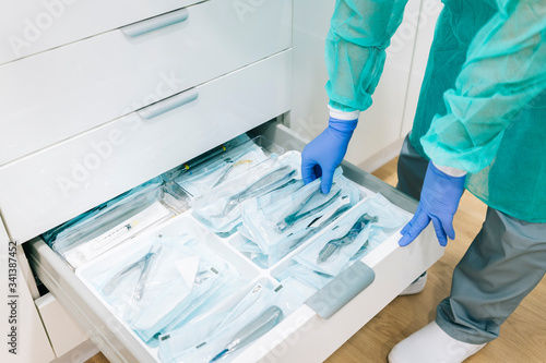 Doctor taking sterile instruments form cabinet photo