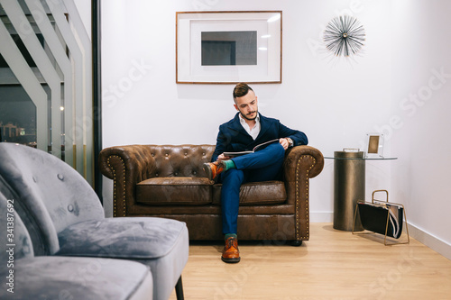 Patient in waiting room of a medical practice reading a magazine photo