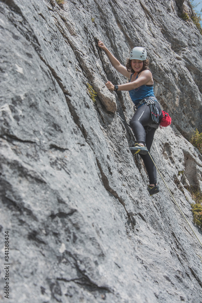 Female mountain climber climbing rock face Female mountain climber climbing rock face
