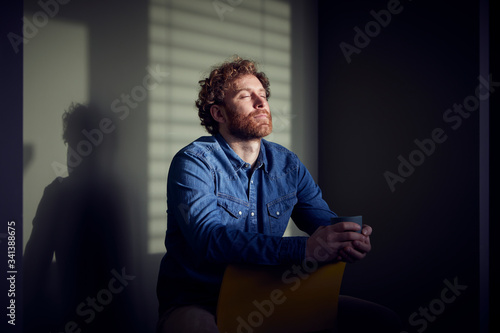 Relaxed casual businessman sitting down with closed eyes