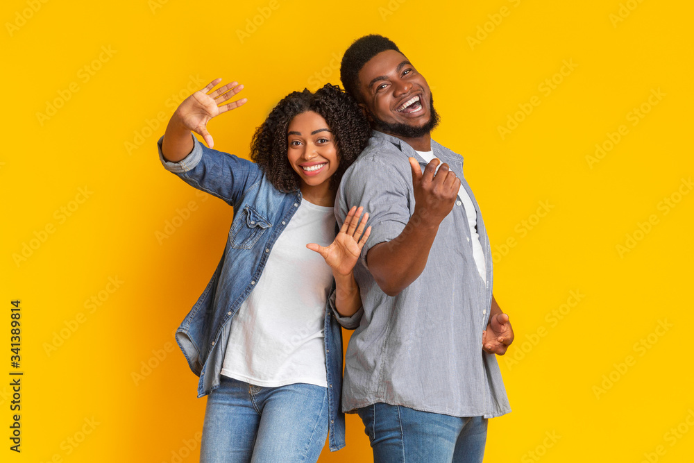 Fototapeta premium Black young couple in good mood having fun over yellow background