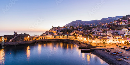 Portugal, Madeira, Camara de Lobos, Clear sky over bay of coastal town at dusk photo