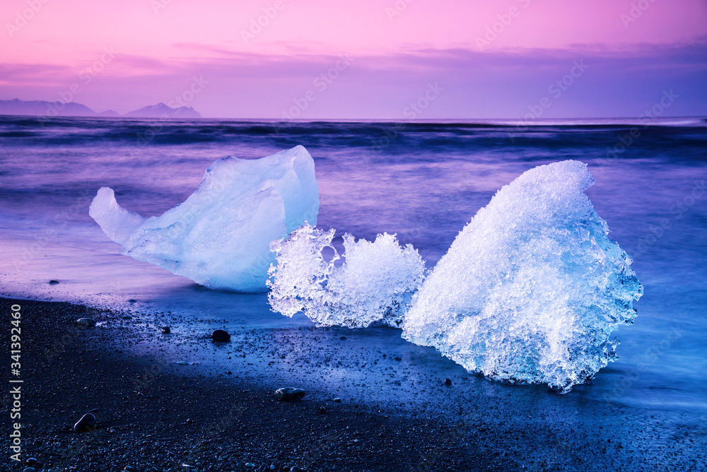 magical charming beautiful landscape with a piece of ice like a sculpture on the Diamond beach near glacier lagoon Jokulsarlon, Iceland at dawn. Exotic countries. Amazing places.