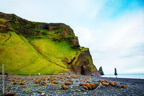 Obraz na płótnie Beautiful dramatic landscape with cave in basalt rock on the black sand beach on Reynisdrangar Sea Cliffs, stones called Troll under the Reynisfjall Mountain near Vik, Iceland. Exotic countries. w salonie