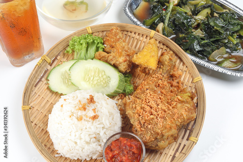 Ayam penyet East Javanese cuisine smashed fried chicken dish with floss sambal slices of cucumbers fried tofu and tempeh Stair fired green Chinese broccoli garlic oyster sauce soup