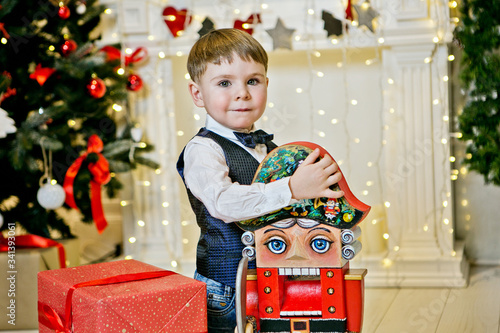 boy with a nutcracker next to a new year tree photo