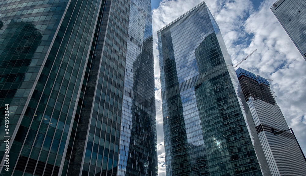 Obraz premium modern building made of glass and concrete, view from below against the sky.