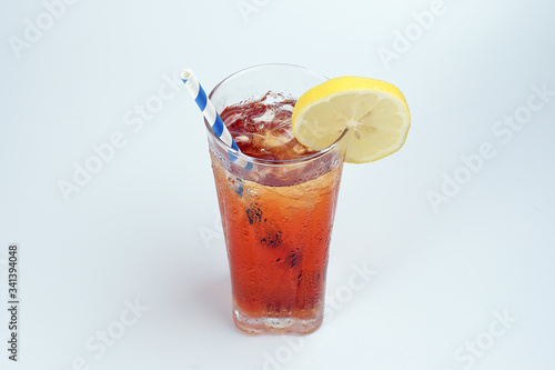 Ice lemon tea with ice cube yellow lemon slice blue white paper straw on white background