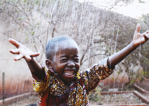 Fotografija African Black Boy Cheerful So Unbelievably Happy to get Water from Rain in Dry S