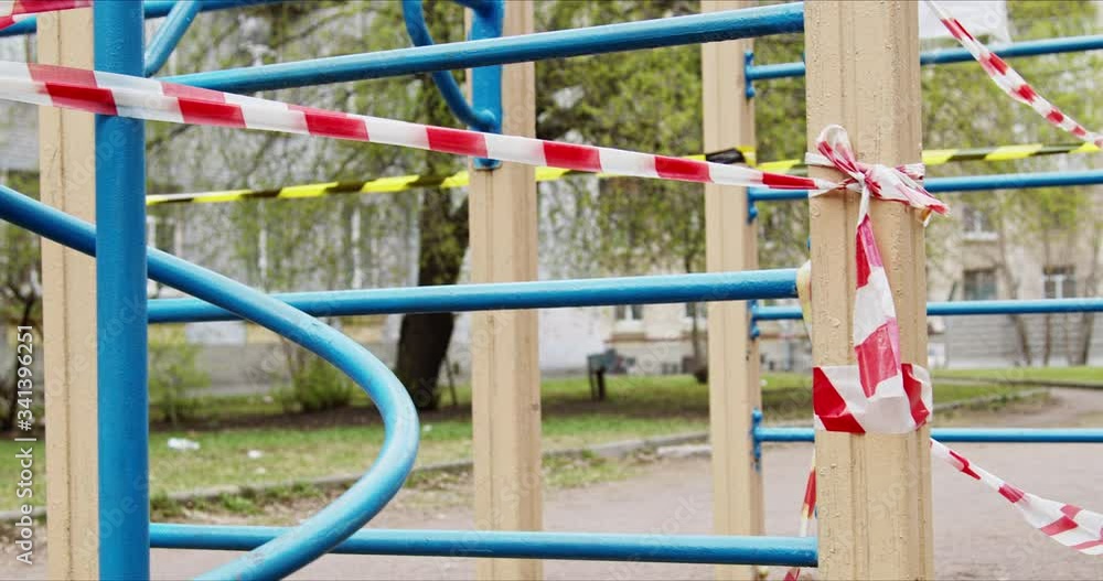 Playground closed by striped tape fencing for quarantine during the coronavirus epidemic Playground closed by striped tape fencing for quarantine during the coronavirus epidemic