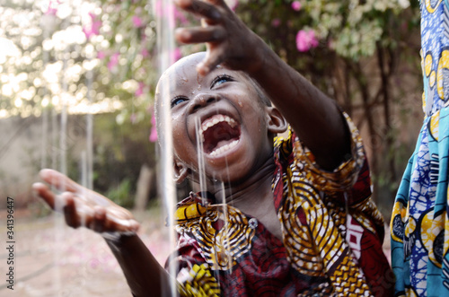 Incredibly Happy African Child Enjoying the Rain as a Water Scarcity Symbol