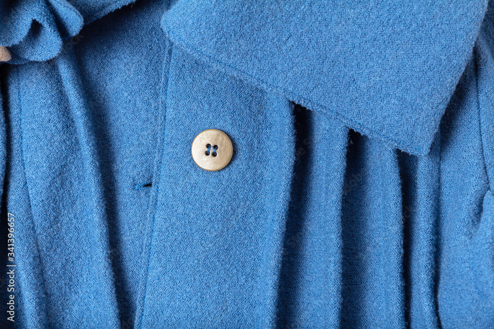 Blue wool texture coat with collar and button close up Blue wool texture coat with collar and button close up
