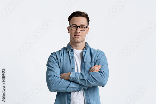 Attractive guy with glasses folded hands, empty space