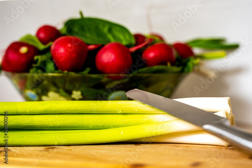 Metal knife over bunch of fresh green onions