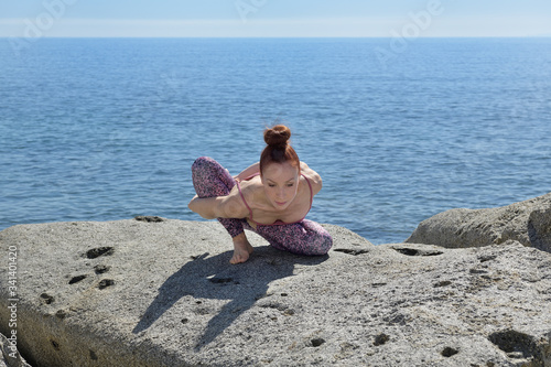 Portrait of a fit woman who practices yoga outdoors. Woman practicing asanas on a sunny day