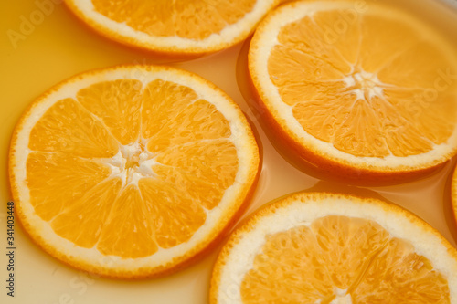 Round fresh orange slices  summer yellow background.