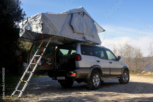 All terrain car with a roof tent unfolded on the roof