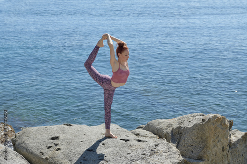 Portrait of a fit woman who practices yoga outdoors. Woman practicing asanas on a sunny day