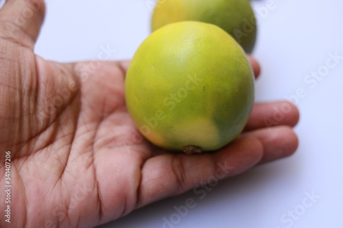 Hand holding yellow color sliced ripe Sweet lime fruit or Citrus limetta