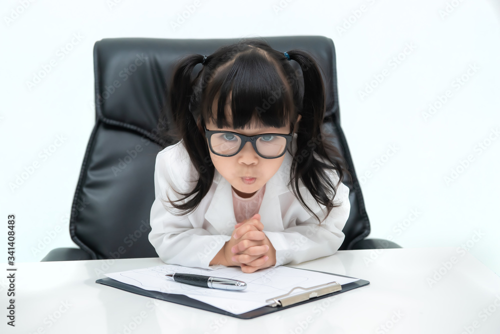 Portrait of cute asian little girl in doctor uniform working on the desk on white background Portrait of cute asian little girl in doctor uniform working on the desk on white background