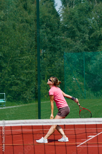 Female tennis player prepares to serve