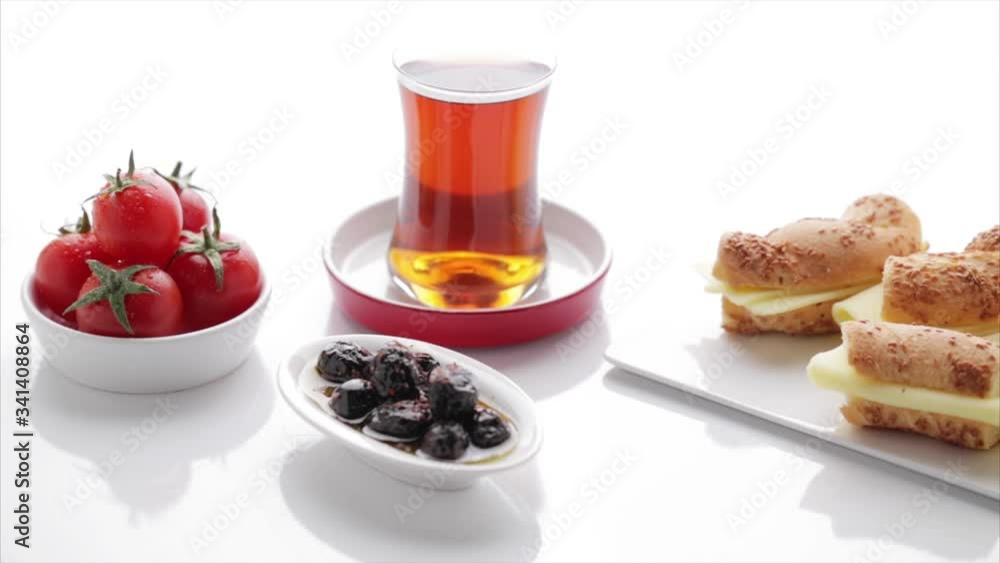 Turkish tea, simit, tomato, olive, cheese on isolated white background Turkish tea, simit, tomato, olive, cheese on isolated white background