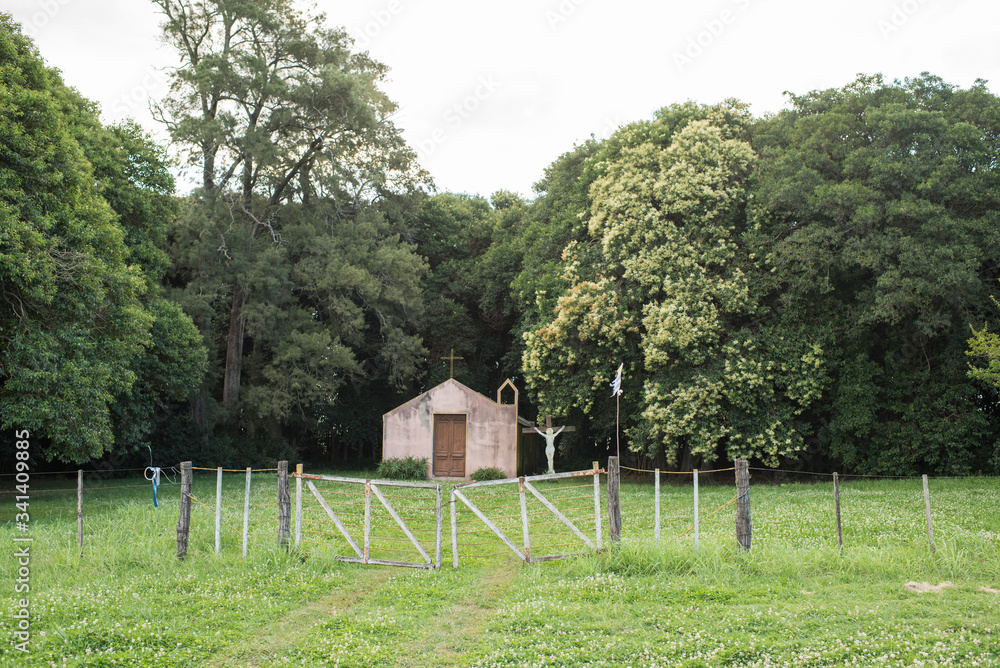 Small building with a cross and a crucified Christ next to it, rural Uruguay Small building with a cross and a crucified Christ next to it, rural Uruguay
