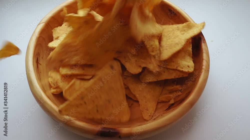 pours corn chips nachos into a bowl in close-up. slow motion pours corn chips nachos into a bowl in close-up. slow motion