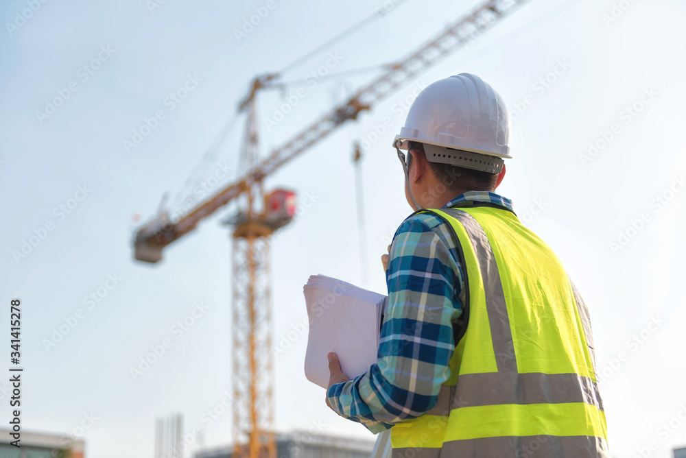 Civil engineer inspects work using radio communication with the management team in the construction area. Civil engineer inspects work using radio communication with the management team in the construction area.