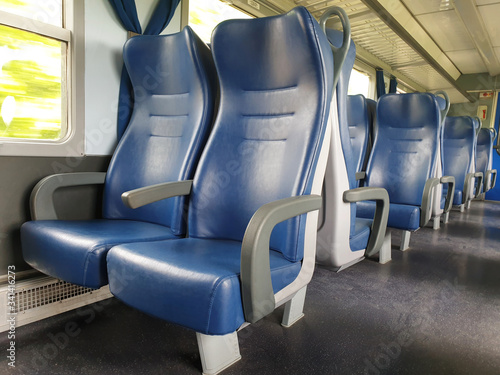Blue row of seats in the cabin of the train in Europe. Empty train car.
