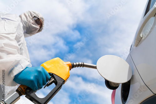 Refuelling the car at a gas station fuel pump. Drop of the prices in fuel industry affected by corona viruses photo