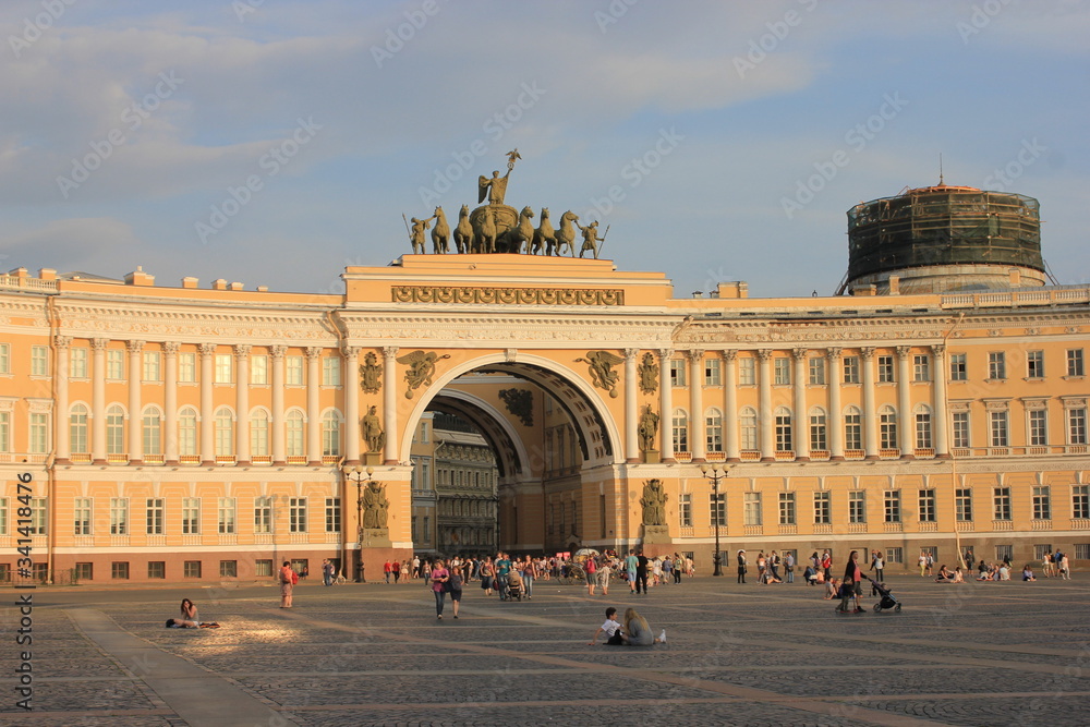 Petersburg, Russia - JULY 25 2018: Palace Square. People sitting on the cobbled road and rest on the background of old buildings