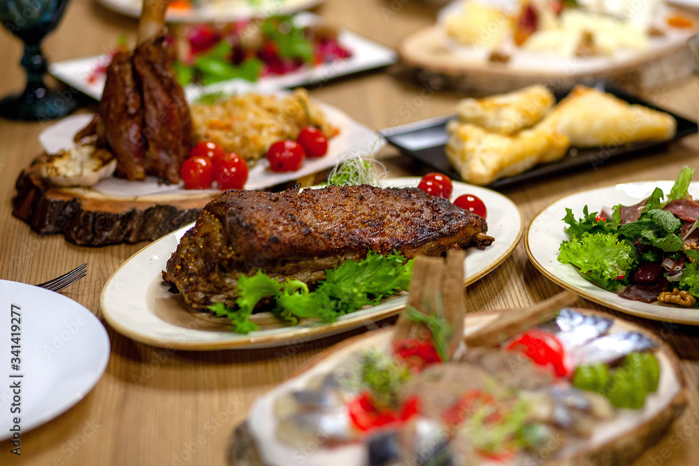 
meat with greens and tomatoes on a plate