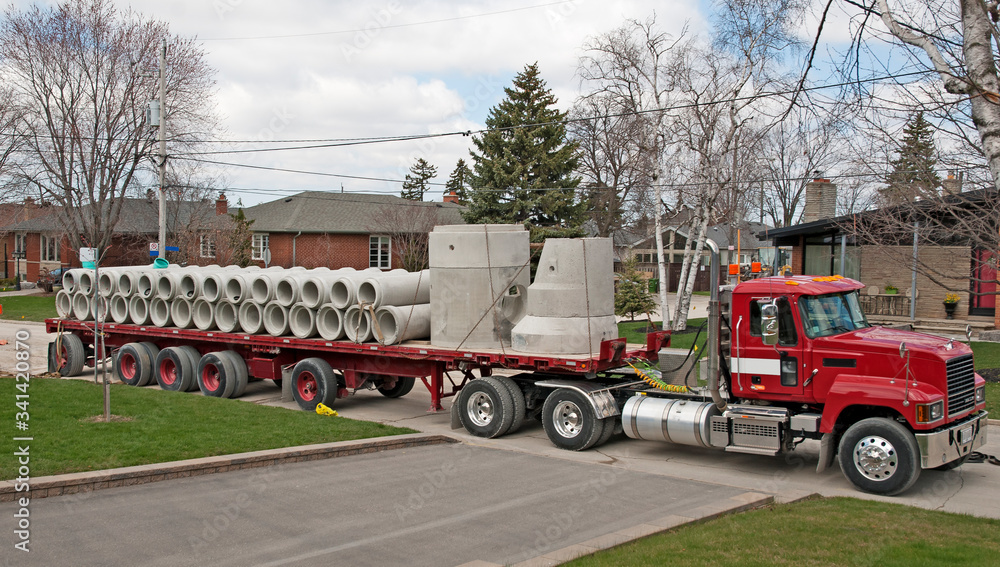 Obraz premium Truck on the road delivering concrete pipe for new sewer system