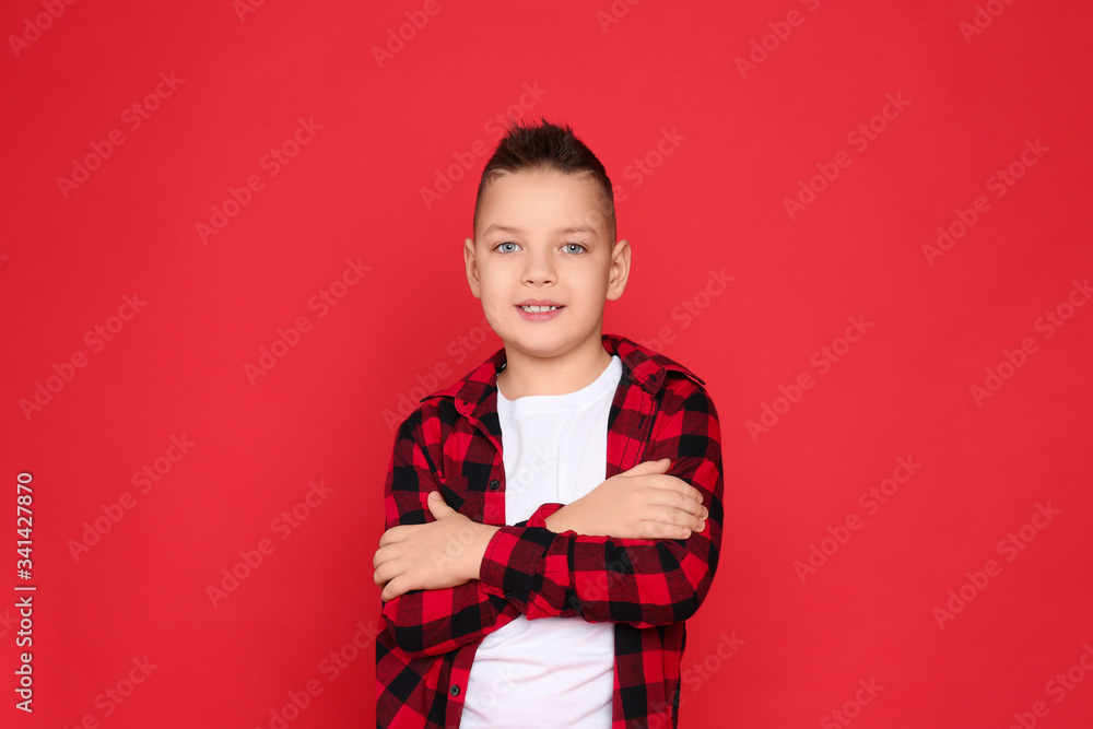 Portrait of cute little boy on red background