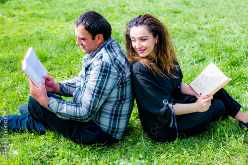 Happy couple reading a book together in garden