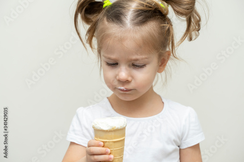 3-4 years old girl in a white t-shirt eating ice cream
