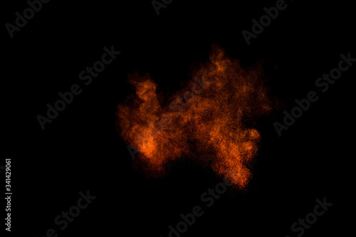 Orange powder explosion on black background. Colored powder cloud. Colorful dust explode. Paint Holi. © sergio34