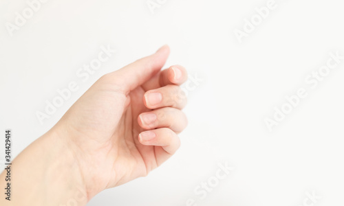 Close up woman hand holds something in fingers. Female keeps virtual object. Nail care at home. Copy space.