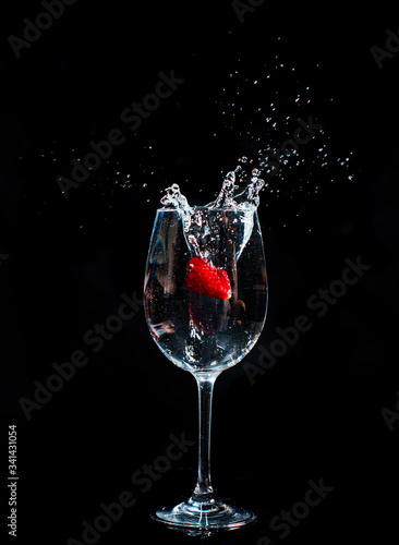 Splashing fruits in to glass of water photo