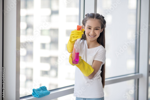Cheerful teenager girl with detergent in her hands.