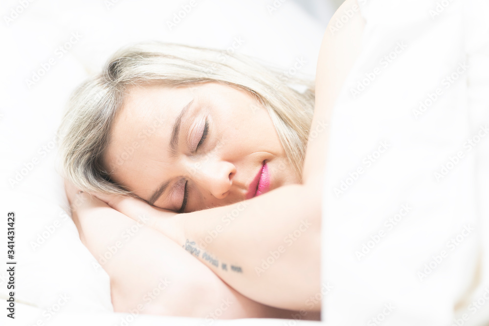 Portrait of an attractive woman sleeping in a bed with white clothes Portrait of an attractive woman sleeping in a bed with white clothes