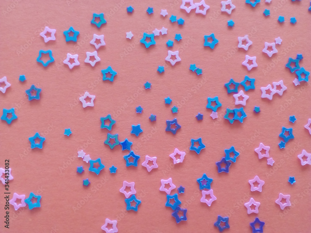 Pink and blue stars of different sizes on a salmon colored background