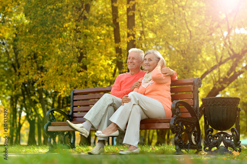 Portrait of happy senior couple sitting in park